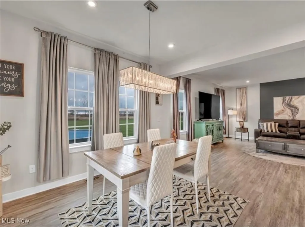 Dining space with wood finished floors and recessed lighting