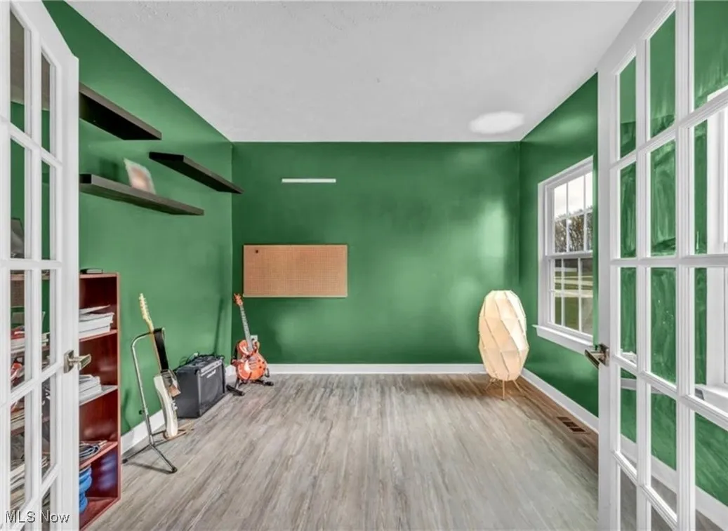 Empty room featuring french doors and wood finished floors