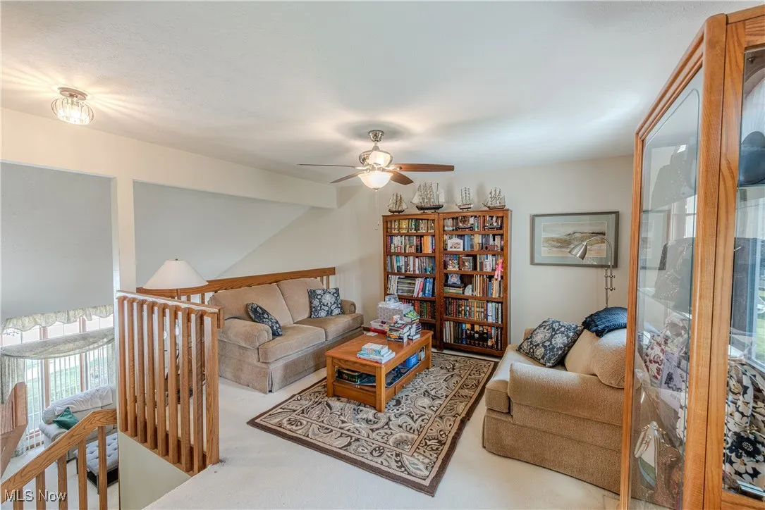 Living area with plenty of natural light, ceiling fan, and gas fireplace
