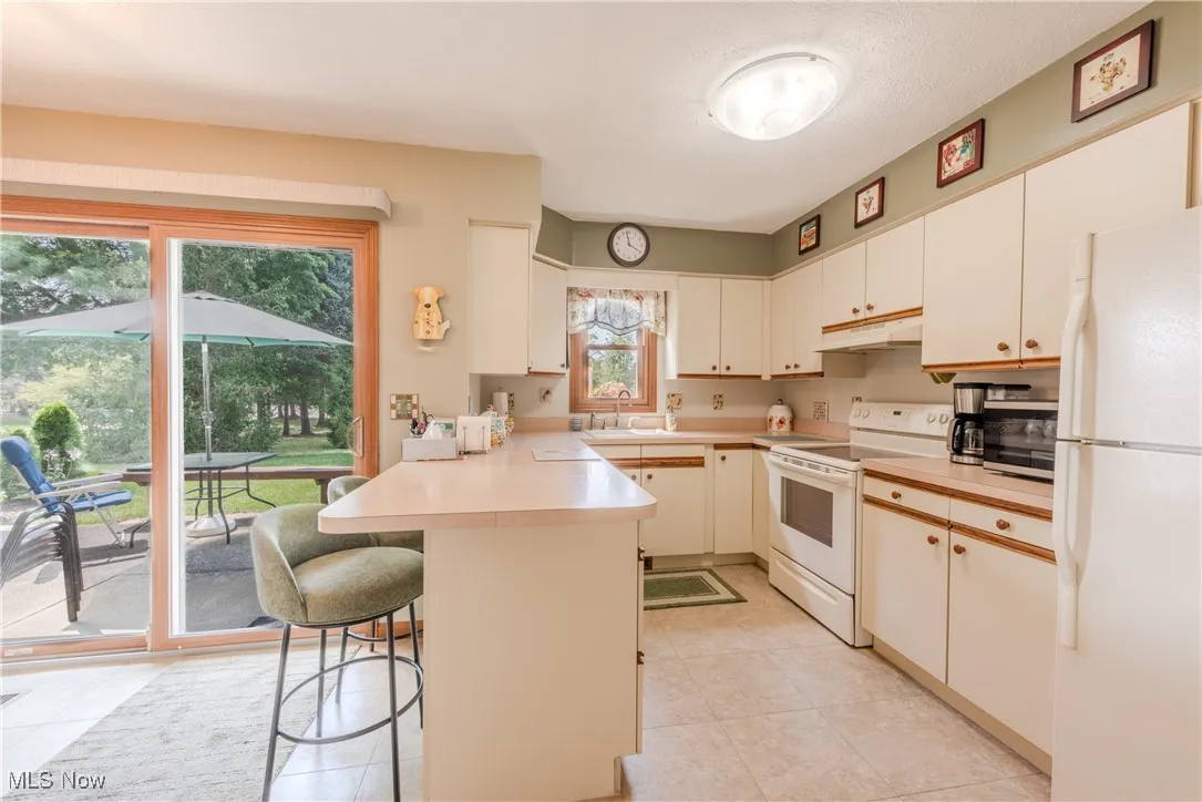 Kitchen with white appliances and a breakfast bar