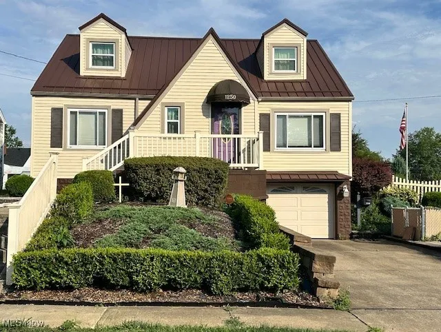 Front view of home with driveway, and a garage