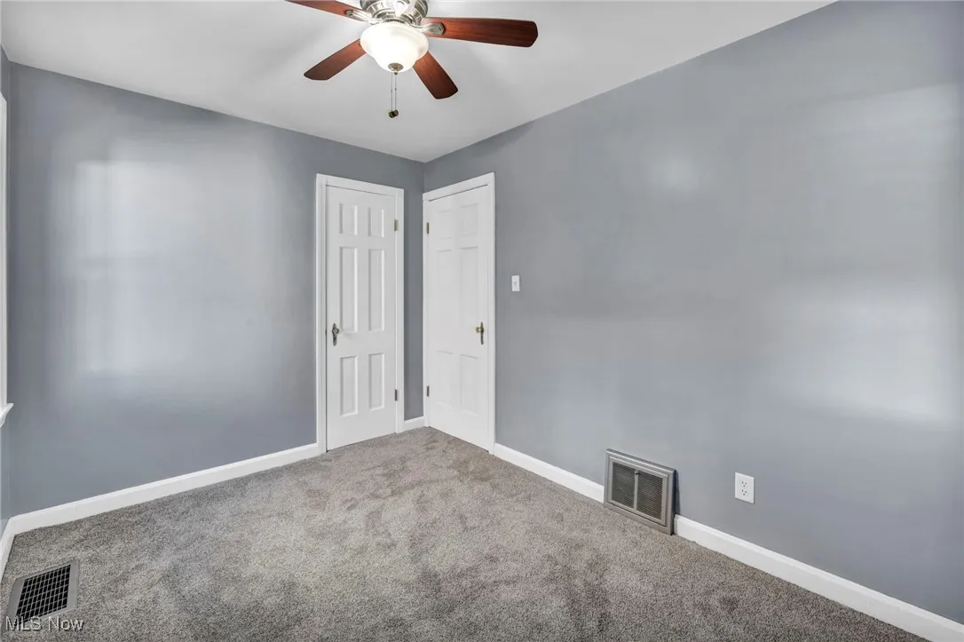 Unfurnished room featuring carpet and ceiling fan