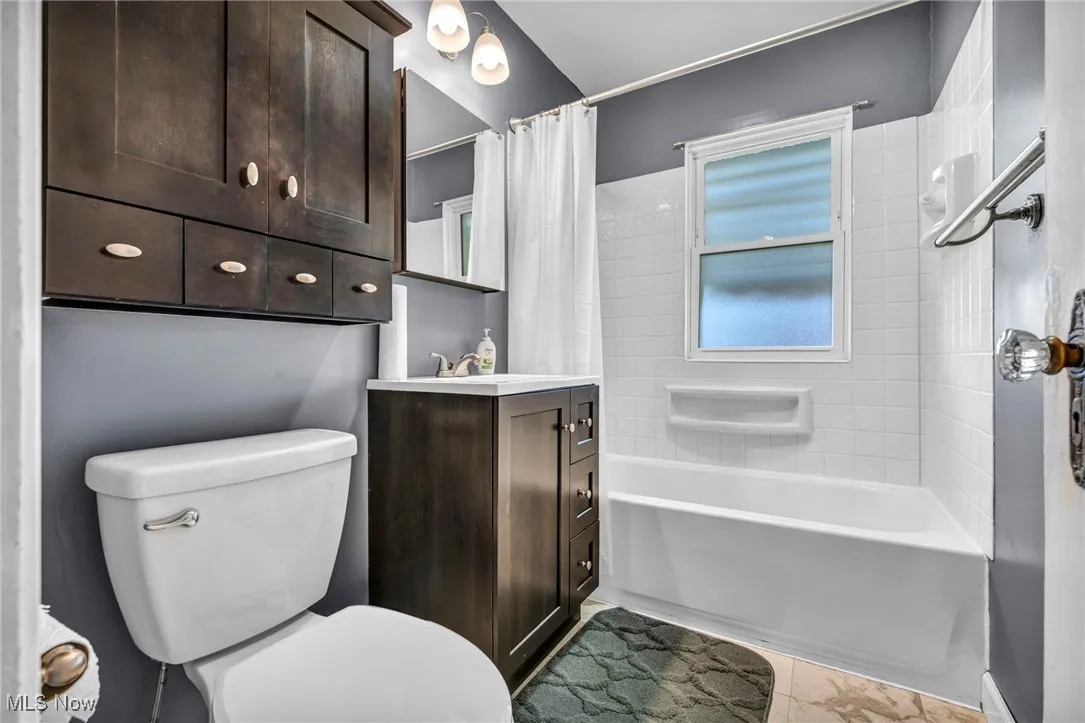 Bathroom featuring vanity, shower / tub combo, and plenty of natural light