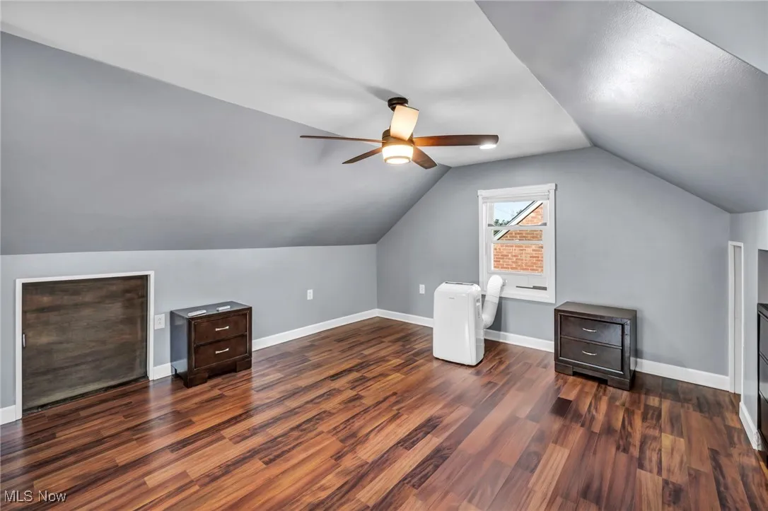 Additional living space with wood finished floors, lofted ceiling, and ceiling fan