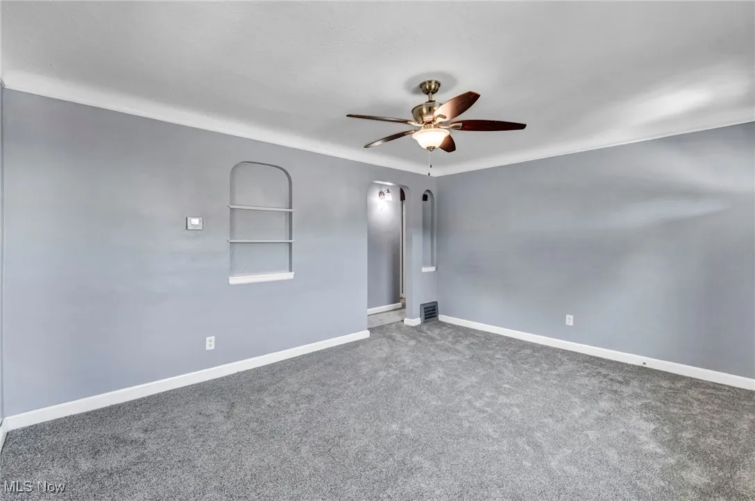 Spare room featuring carpet and ceiling fan