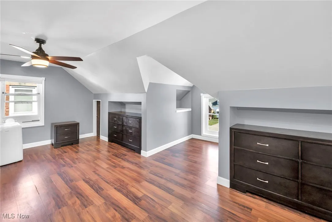 Bonus room with wood finished floors, lofted ceiling, and a ceiling fan