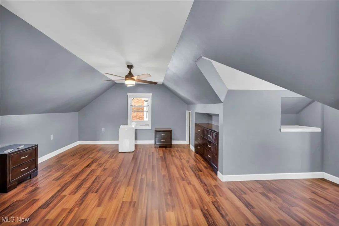 Bonus room with wood finished floors, lofted ceiling, and a ceiling fan