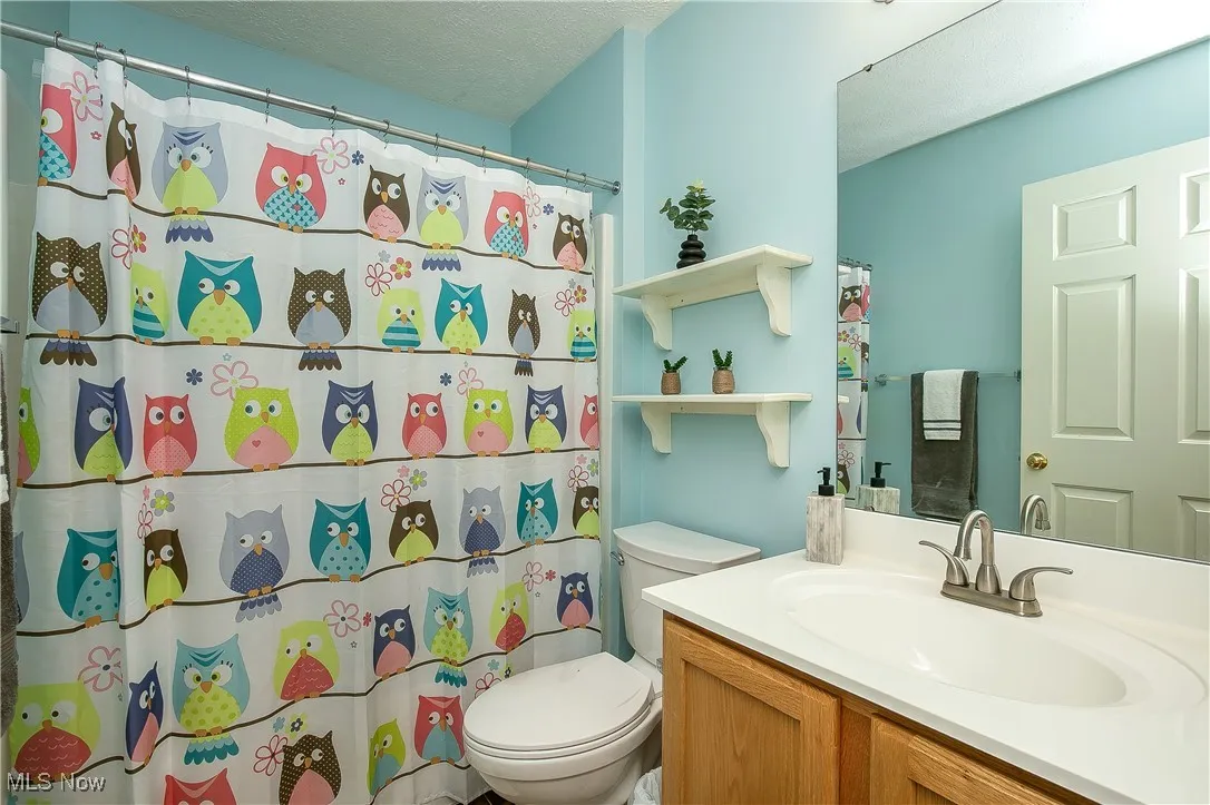Bathroom featuring vanity, a textured ceiling, and a shower with curtain