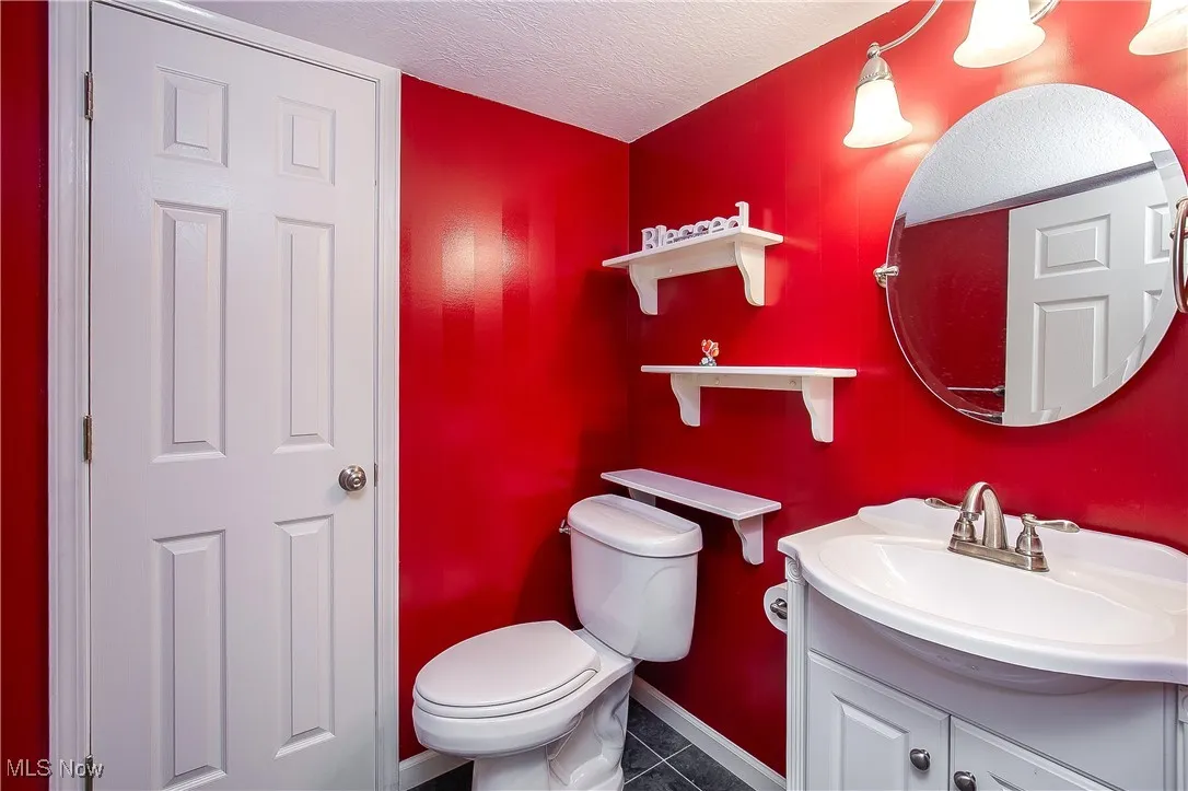 Bathroom with a textured ceiling, vanity, and tile patterned floors