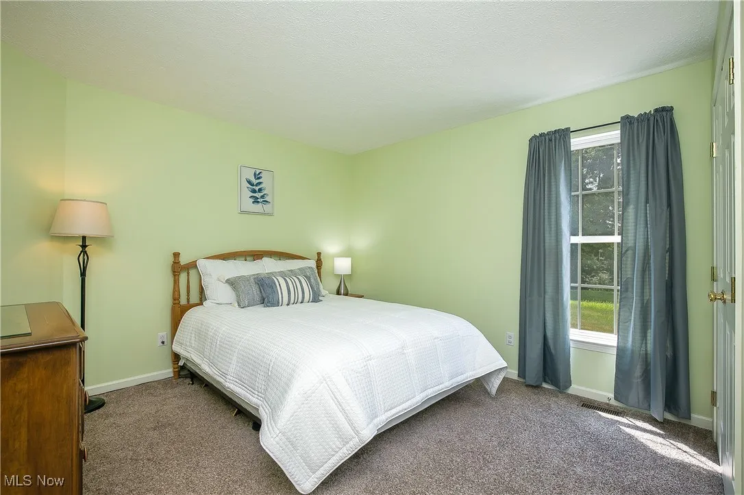 Bedroom with carpet floors and a textured ceiling
