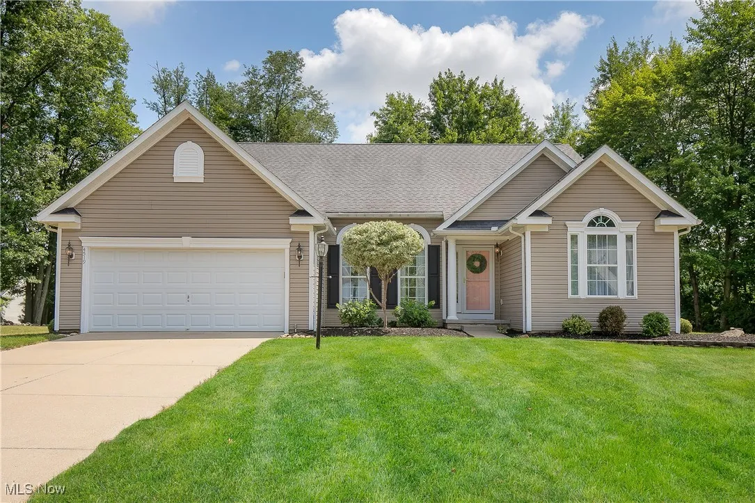 Single story home with concrete driveway, a front lawn, and a garage
