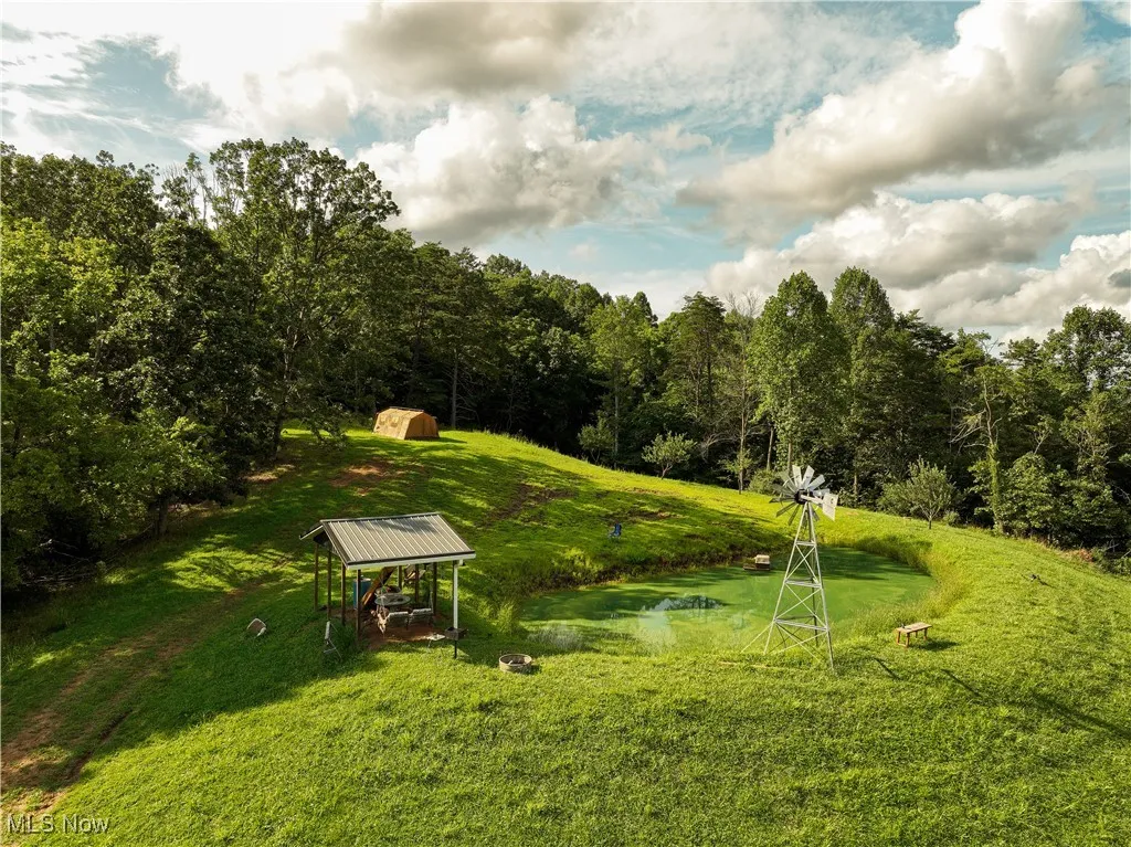 View of home's community featuring a lawn, an outbuilding, and a view of trees