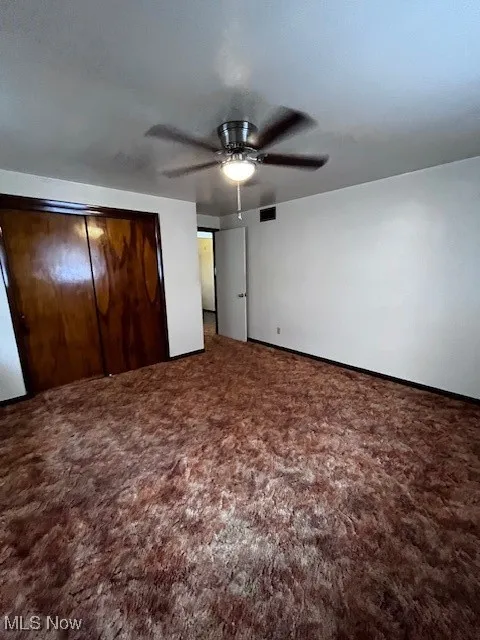 Unfurnished bedroom with carpet, a closet, and ceiling fan