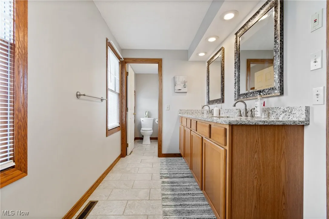 Full bath featuring double vanity and recessed lighting