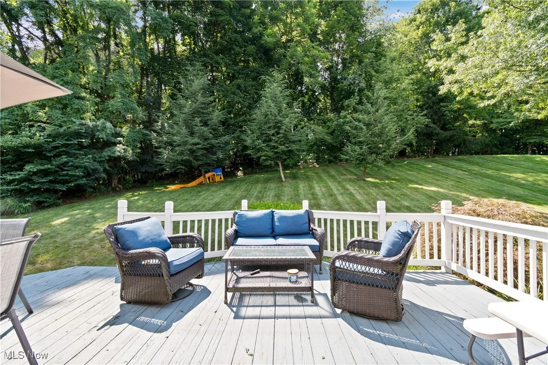 Deck with outdoor lounge area, a playground, and a lawn