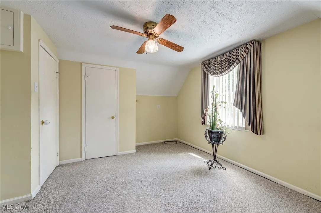 Bonus room featuring vaulted ceiling, a ceiling fan, carpet, and a textured ceiling