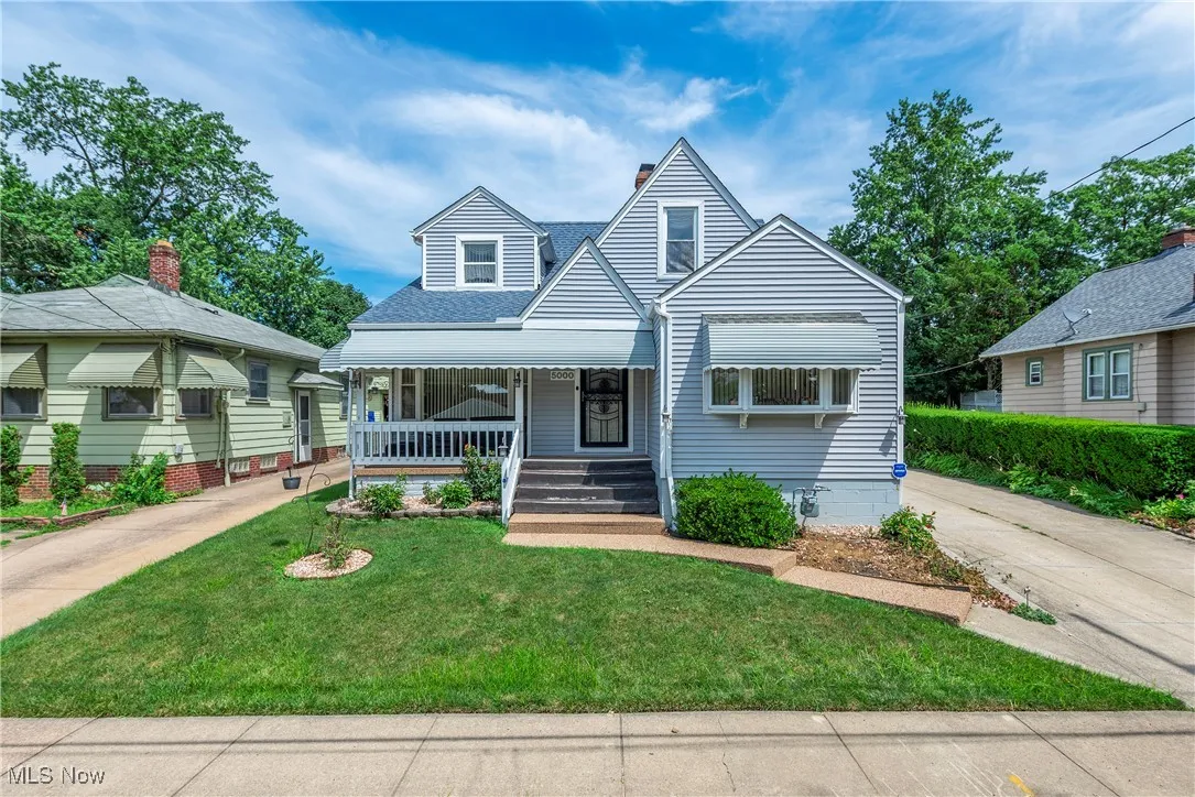 Bungalow with covered porch, a front lawn, a chimney, and a shingled roof