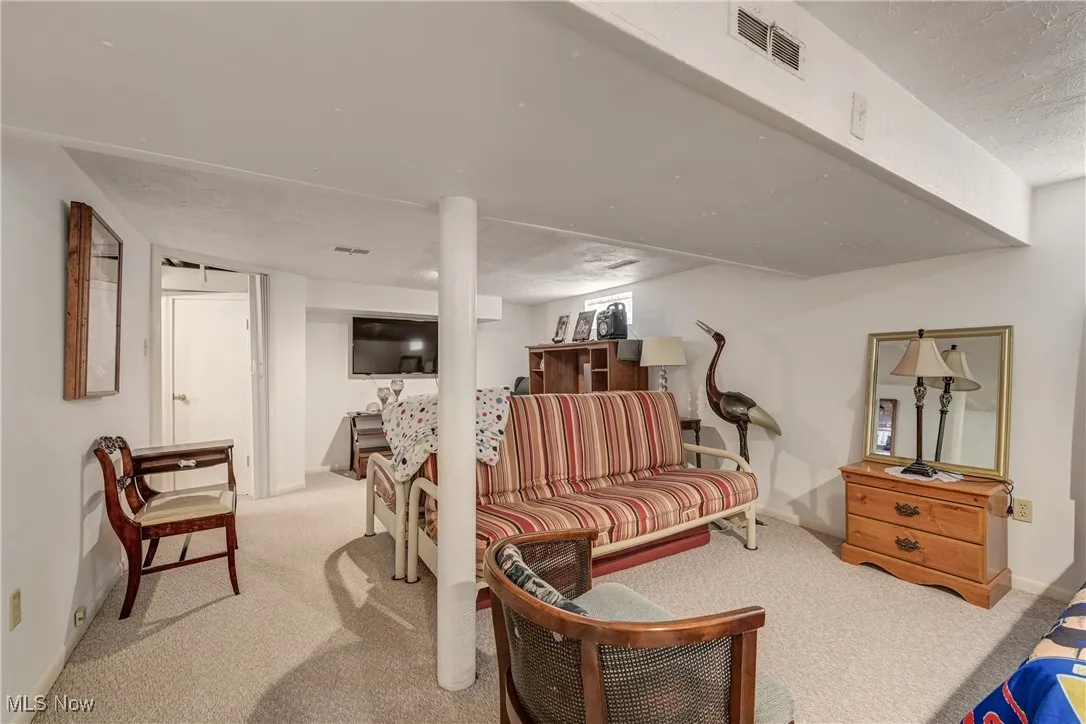 Carpeted living area featuring a textured ceiling