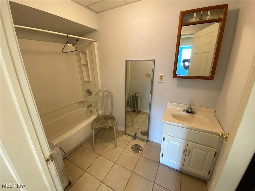 Bathroom featuring tile patterned floors, bathtub / shower combination, vanity