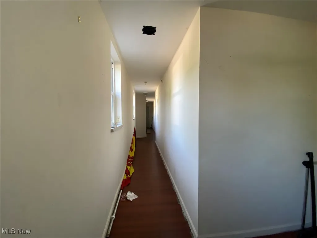 Corridor with dark hardwood / wood-style flooring