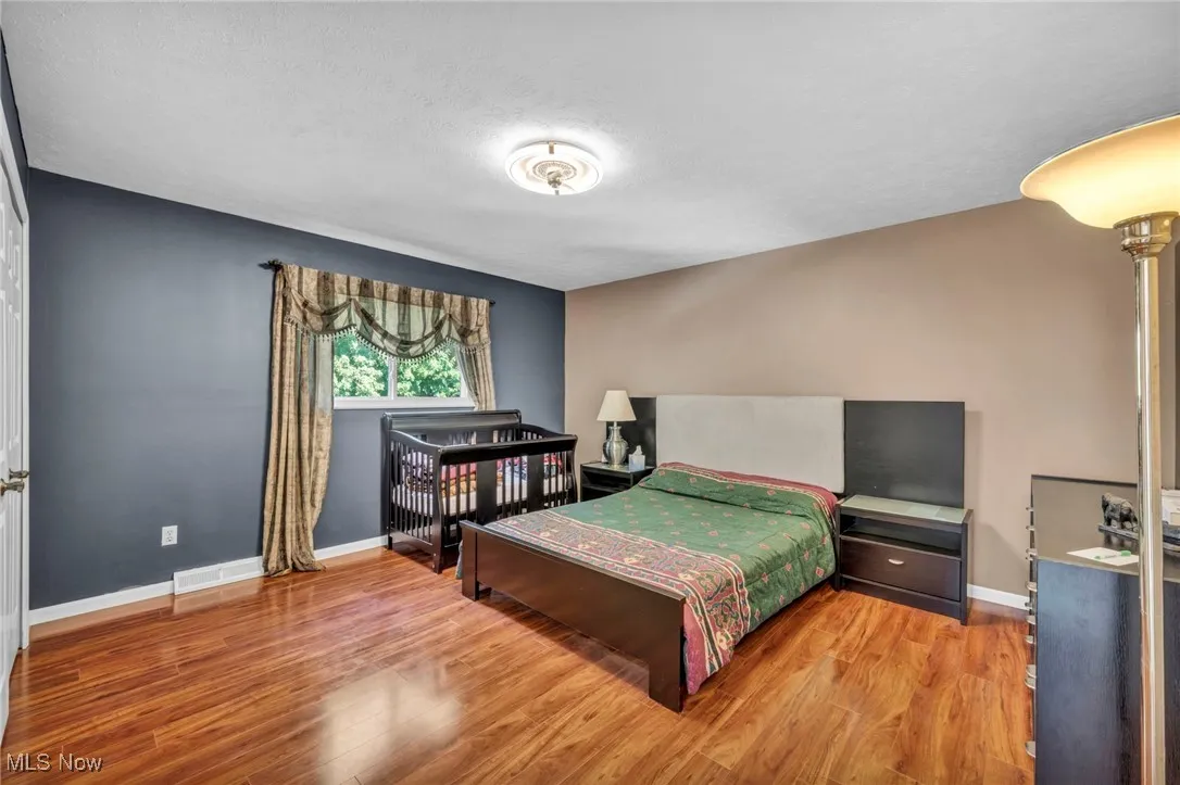 Bedroom with wood finished floors and a textured ceiling