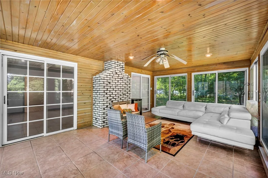 Sunroom / solarium featuring tile patterned flooring, wooden ceiling, wood walls, and recessed lighting