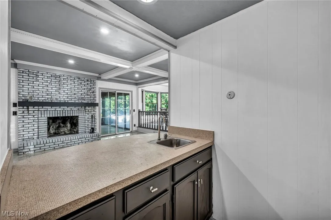 Kitchen with beam ceiling, recessed lighting, a brick fireplace, and coffered ceiling