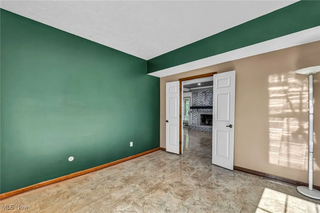 Spare room with baseboards and a fireplace