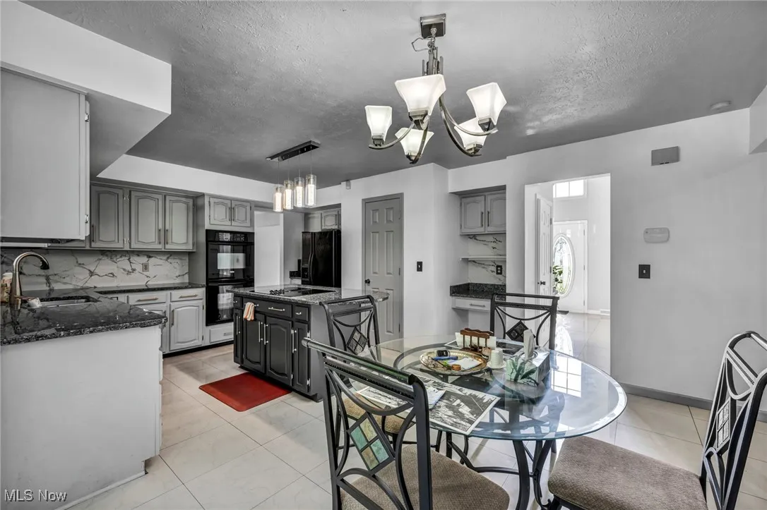 Dining room with a chandelier, a textured ceiling, and light tile patterned floors