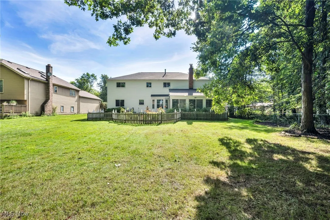 Back of property with a chimney, a sunroom, and a fenced backyard