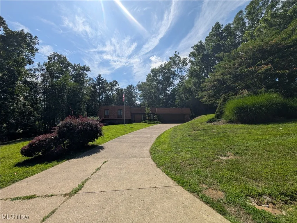View of front of house featuring a front lawn, driveway, and an attached garage
