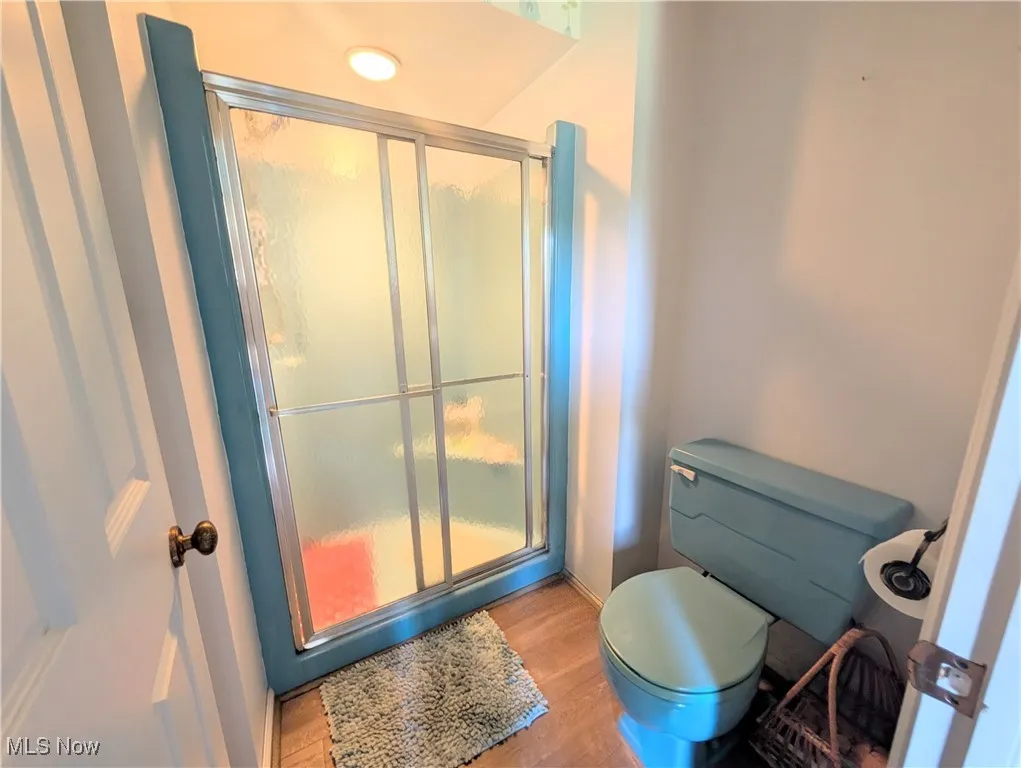 Bathroom with a stall shower and wood finished floors