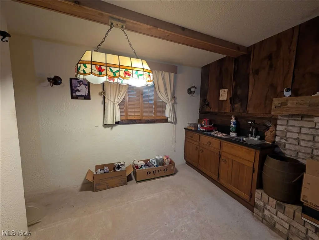 Bar area featuring beamed ceiling, a textured ceiling, and decorative light fixtures