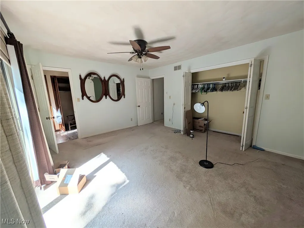 Unfurnished bedroom featuring carpet floors, a closet, and ceiling fan