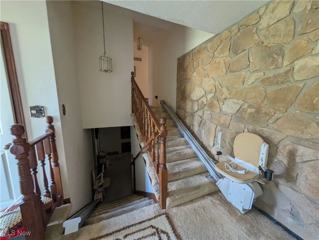 Stairs featuring a textured ceiling and a towering ceiling