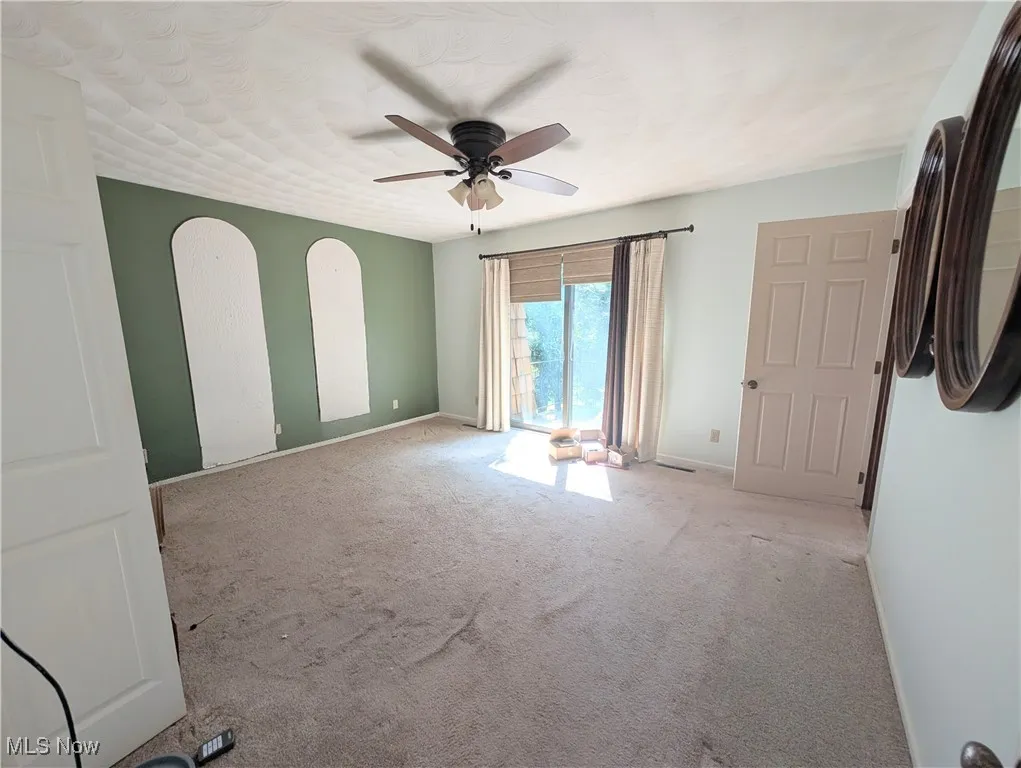 Empty room featuring carpet floors and ceiling fan