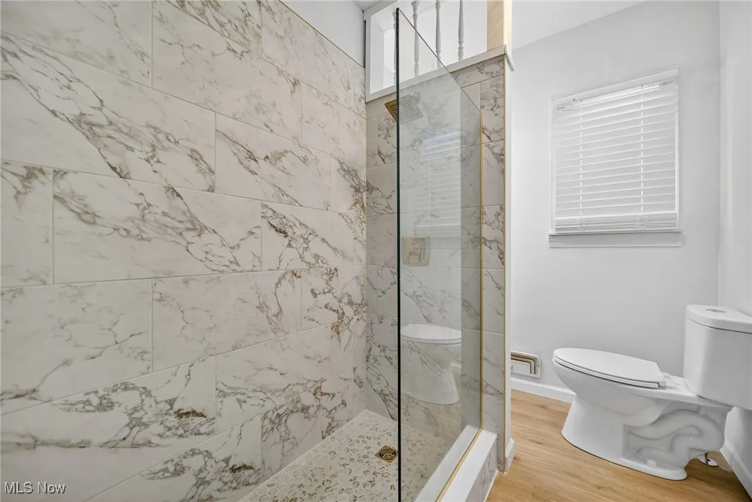 Full bath with a walk in shower and wood finished floors