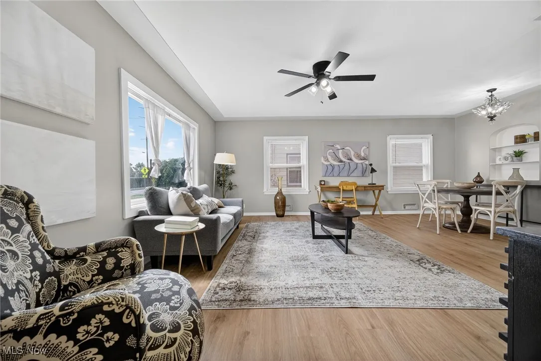 Living area with wood finished floors, ceiling fan, and a chandelier