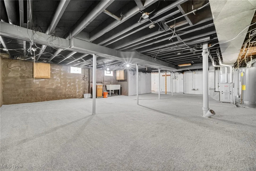 Below grade area featuring water heater and heating unit