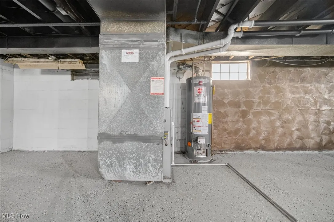 Below grade area featuring heating unit and water heater