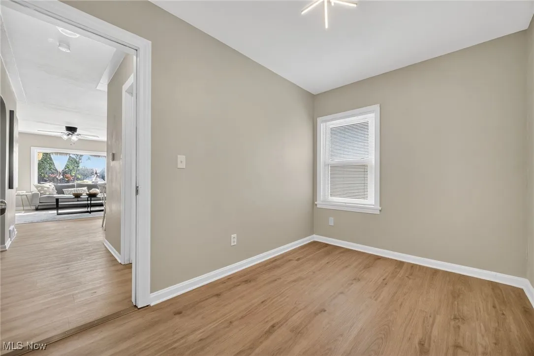 Unfurnished room with light wood-style flooring and vaulted ceiling