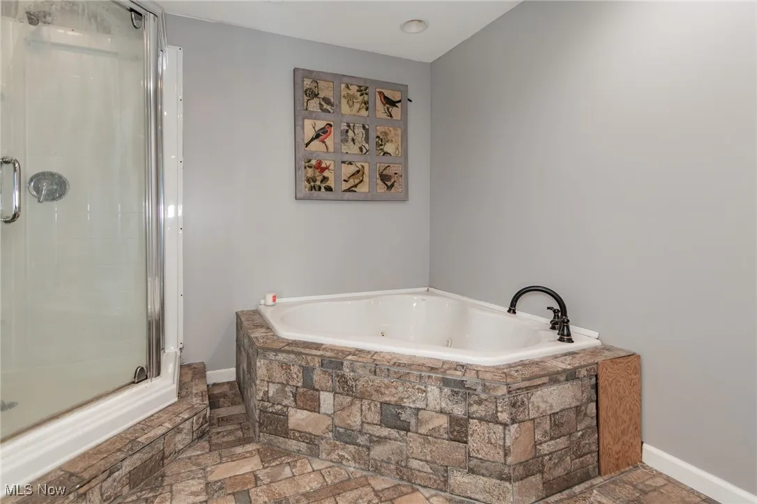 Full Primary bathroom with a shower stall and a tub with jets