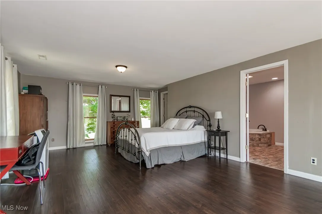 Primary Bedroom featuring wood finished floors and baseboards