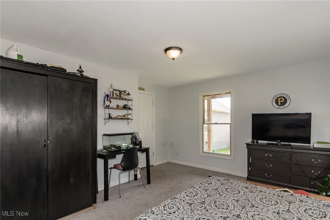 First Floor Carpeted bedroom with an office area and a closet