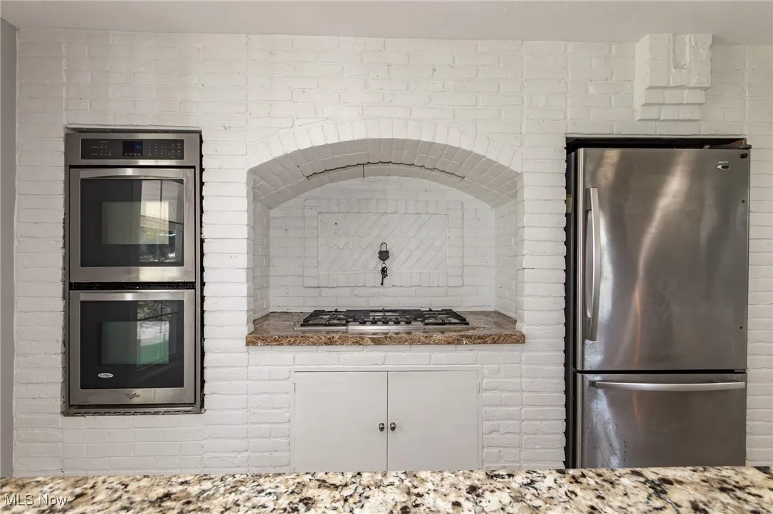 Kitchen featuring stainless steel appliances and light stone counters
