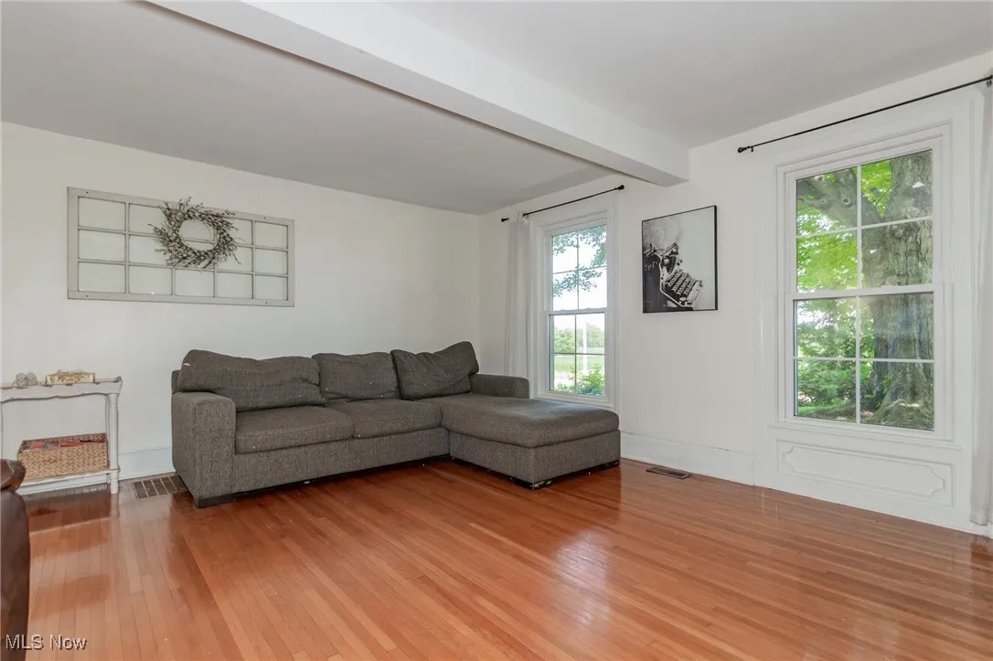 Living area featuring beam ceiling and light wood finished floors