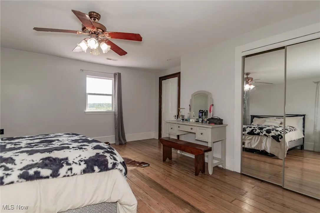 Bedroom 4 featuring wood-type flooring, a ceiling fan, and a closet