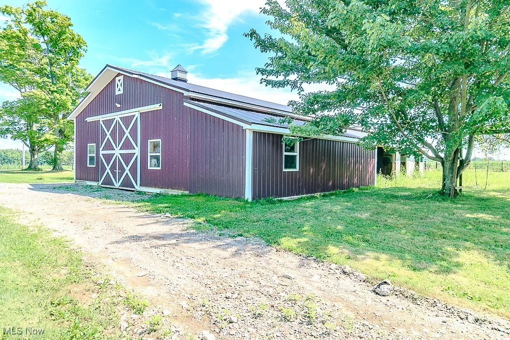 View of barn featuring a lawn