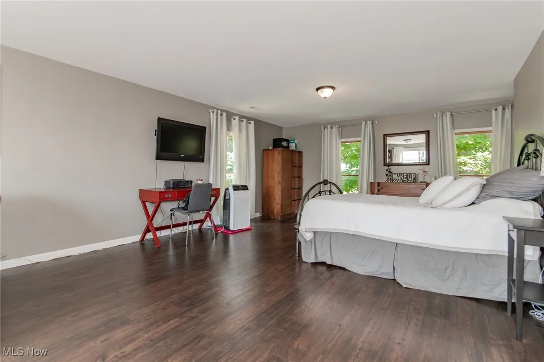 primary Bedroom with wood finished floors and baseboards