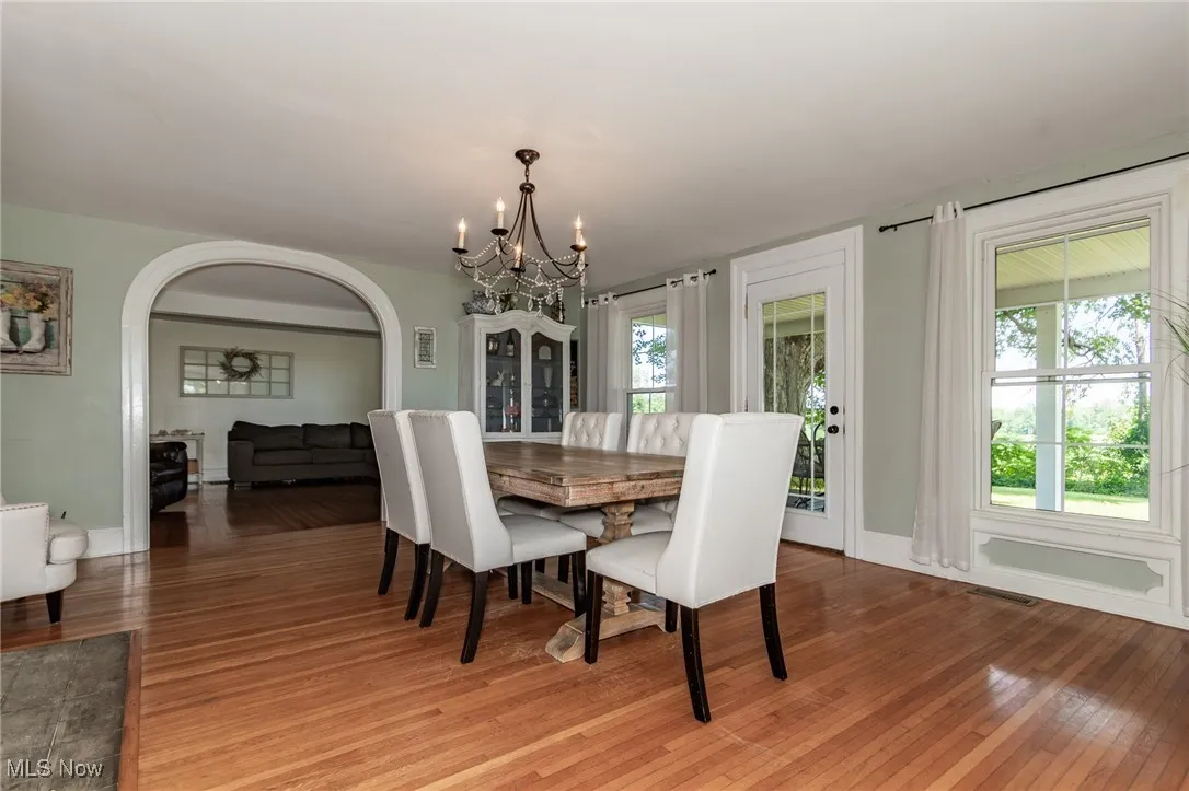 Dining room featuring a chandelier, light wood-style floors, and arched walkways